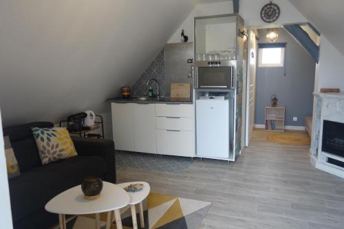 ein Wohnzimmer mit einem Sofa und einer Küche in der Unterkunft O'bon'Eure in Bray