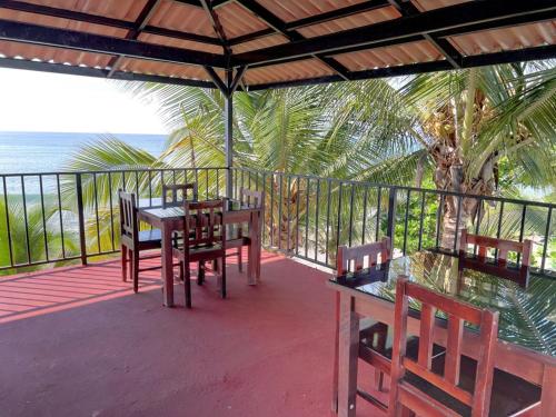 un porche con mesa, sillas y el océano en Big Daddy's Beach Club & Hotel, en Puerto Armuelles