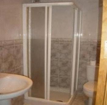 y baño con ducha, aseo y lavamanos. en Hostal Emilio Barajas, en Madrid