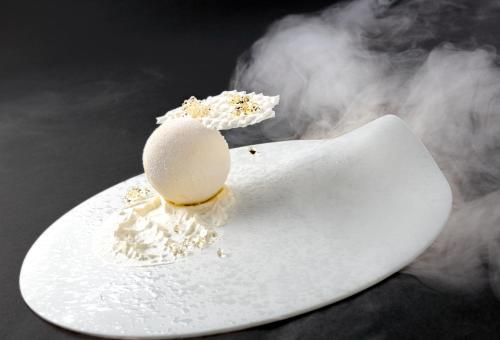 an egg on a white board with smoke at Hotel Weiher Green Lake in Falzes