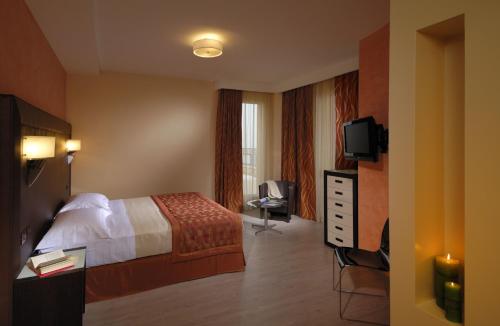 a hotel room with a bed and a television at Hotel La Cartiera in Vignola
