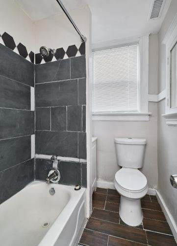 a bathroom with a toilet and a tub and a sink at 1 Bd Apt near forest park, Science Center & dining in Tower Grove
