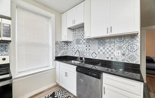 a kitchen with white cabinets and a dishwasher at 1 Bd Apt near forest park, Science Center & dining in Tower Grove