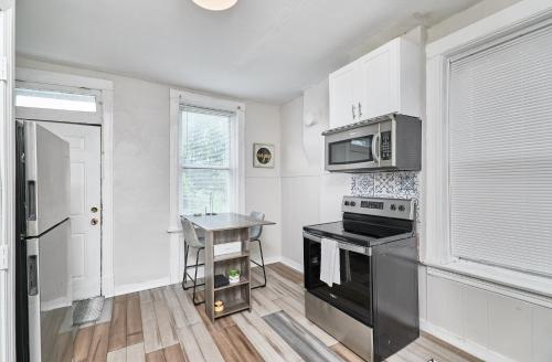 a kitchen with a stove and a microwave at 1 Bd Apt near forest park, Science Center & dining in Tower Grove