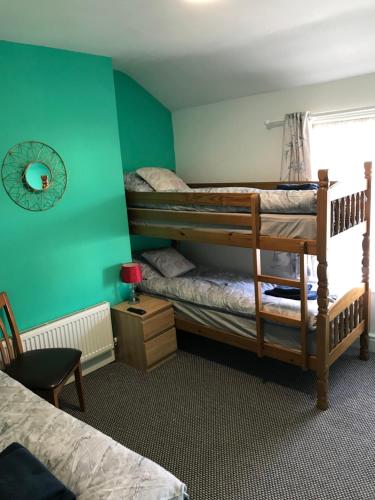 two bunk beds in a room with green walls at Yado Hotel in Blackpool