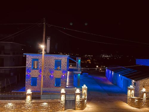 a brick building with lights on it at night at ΒΙΛΛΑ ΤΟ ΠΕΤΡΙΝΟ stone bild villa full equipment in Nafpaktos