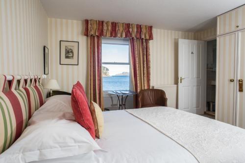 a bedroom with a bed with a view of the ocean at Tigh an Eilean Hotel in Shieldaig