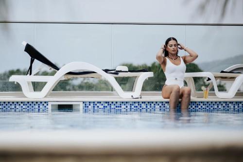 a woman in a swimsuit sitting in a swimming pool at AM Palace in Ulcinj