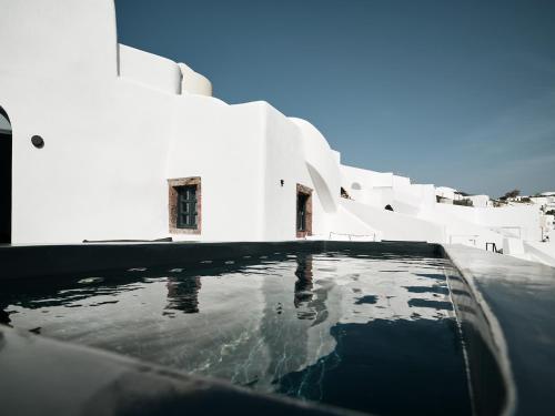 a pool of water in front of a white building at Abyss in Oia