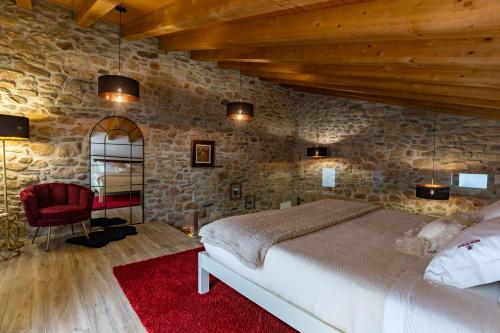 a bedroom with a bed and a stone wall at Adega do Balé in Miranda do Douro