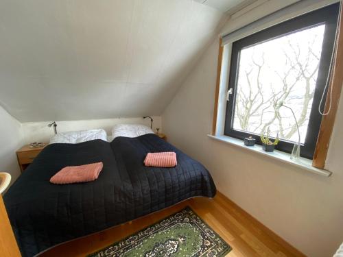 a bed in a small room with a window at Holidayhouse by the sea in Selatrað