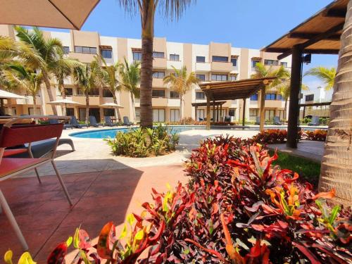 a view of a resort with a pool and palm trees at AMBAR BY HAUSING - Pet Friendly in Mazatlán