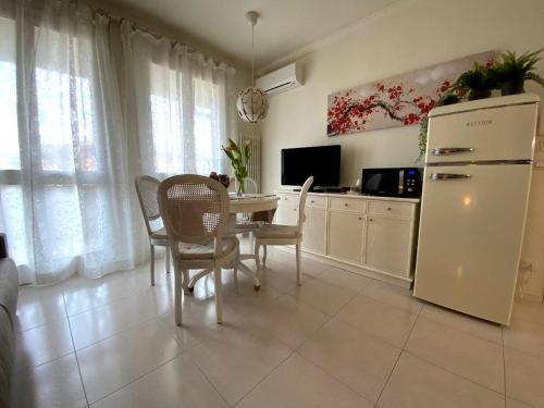 una cucina con tavolo, sedie e frigorifero di Elena Apartment Residence a Bardolino