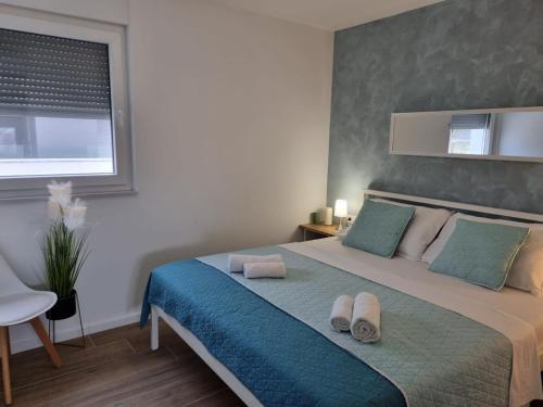 a bedroom with a bed with two towels on it at Apartment Maris Nin in Nin
