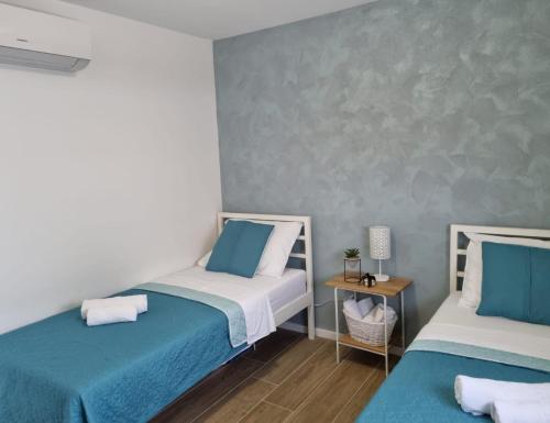 two beds in a room with blue and white at Apartment Maris Nin in Nin