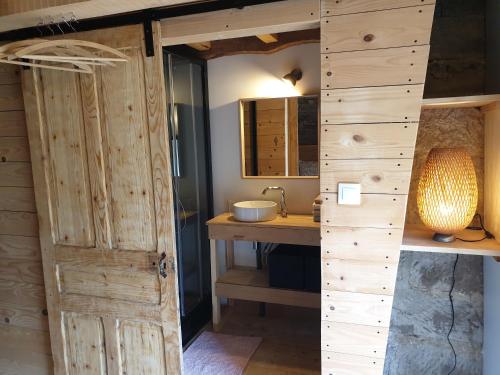 a bathroom with a wooden door and a sink at Les Vergers d'Epona "Fougerolles Haute-Saône" in Fougerolles