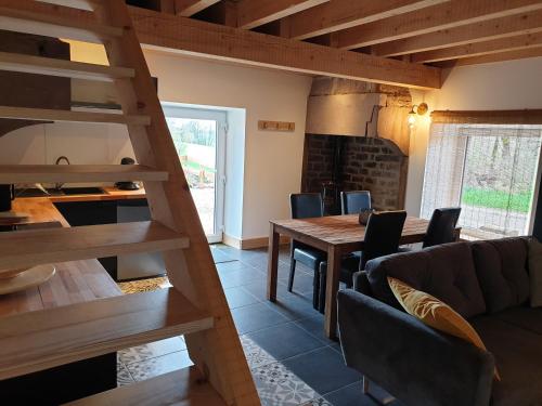 une cuisine et une salle à manger avec une table et des chaises dans l'établissement Les Vergers d'Epona 