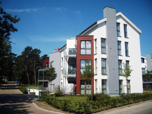 ein weißes und rotes Gebäude auf einer Straße in der Unterkunft Ferienwohnung Baabe in Baabe