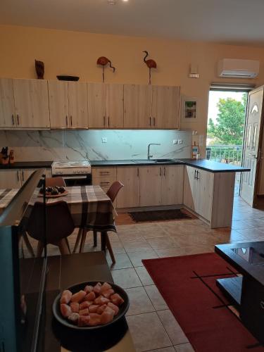 a kitchen with wooden cabinets and a table and a dining room at Cosy apartment in Stoupa in Stoupa