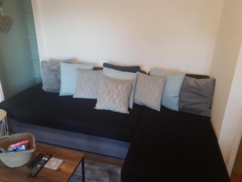 Un sofá con un montón de almohadas. en Topzy-Turvy - 1 Bedroom Apartment en Swansea