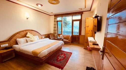 a bedroom with a bed and a large window at Himalayan adventure Cottages & Budget Friendly BNB Manali in Manāli