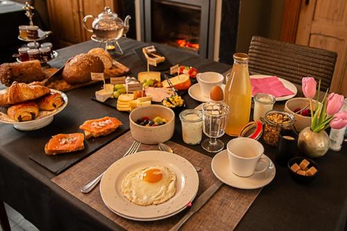 a table with breakfast foods and drinks on it at B&B Pastorie van Merkem in Merkem