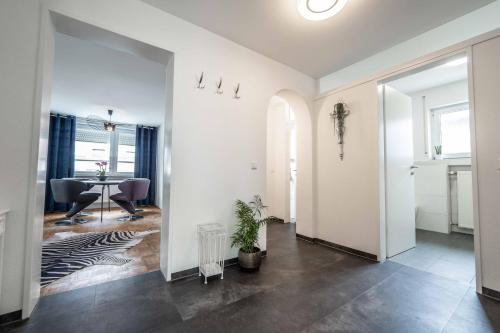 a hallway with a dining room and a table at City Wohnung FN L 5 KLIMATISIERT mit Balkon und Küche in Friedrichshafen