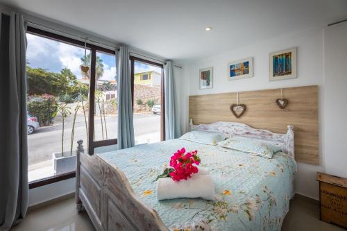 a bedroom with a bed with flowers on it at Apartment Lovely Rose with garden Jacuzzi in Jan Thiel
