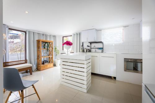 a kitchen with white cabinets and a table and chairs at Apartment Lovely Rose with garden Jacuzzi in Jan Thiel