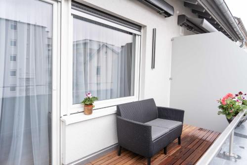 a balcony with a chair and a window at City Wohnung FN L 5 KLIMATISIERT mit Balkon und Küche in Friedrichshafen