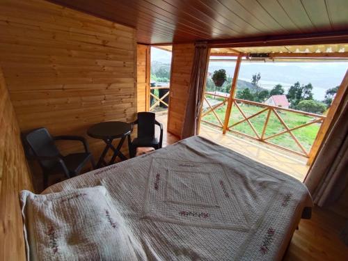 a bedroom with a bed in a wooden room with a window at Cabaña Los Girasoles in Guatavita
