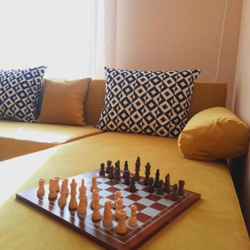 un tablero de ajedrez sobre una mesa con sofá en Апартамент Лидия en Chepelare