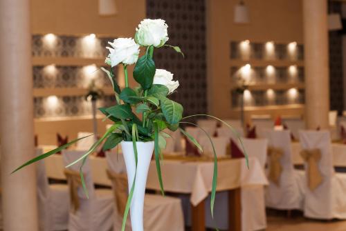 a white vase filled with white flowers on a table at Hotel Marand in Rzeszów