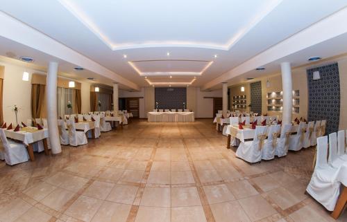 a large banquet hall with white tables and chairs at Hotel Marand in Rzeszów