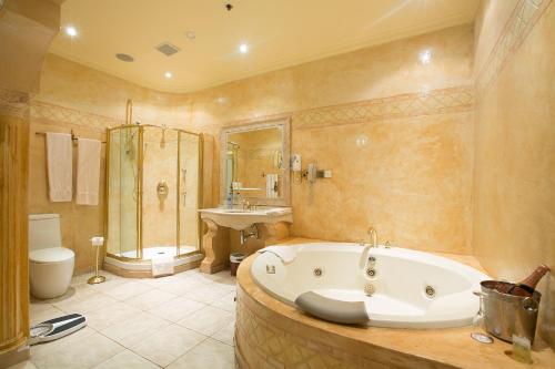 a bathroom with a tub and a shower and a sink at Victoria Crown Plaza Hotel in Lagos