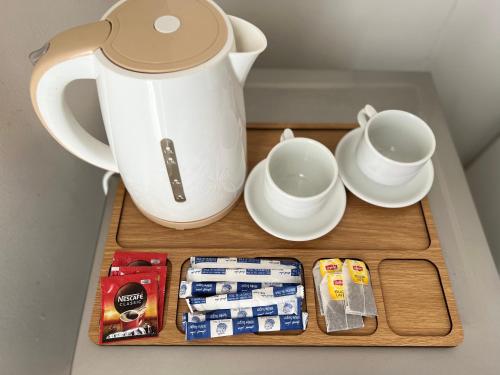 a tea pot and cups on a wooden tray at Pyramids top success result in Cairo