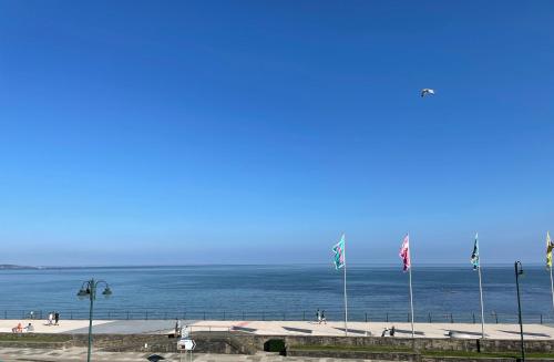 a beach with flags and the ocean in the background at Guest Lodge Penzance in Penzance