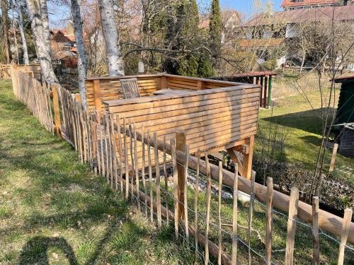 a wooden fence in a yard next to a field at Helle Souterrain Wohnung in Laufnähe zum Wörthsee in Wörthsee