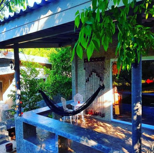 a hammock on the porch of a house at New Moon in Thongsala