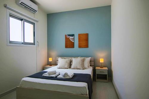 ein Schlafzimmer mit einem Bett mit zwei Tischen und einem Fenster in der Unterkunft Phaedrus Living: City View Fountain Court 113 in Ayia Napa