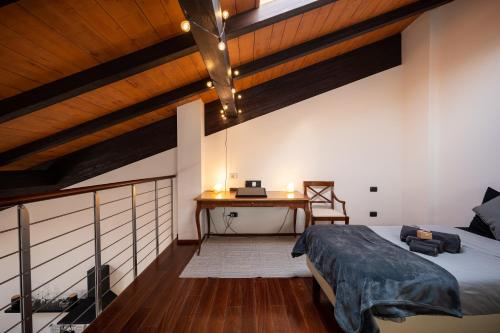 [Chardonnay]- elegante appartamento في Cavezzo: غرفة نوم مع سرير ومكتب مع الكمبيوتر المحمول