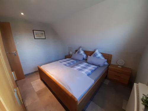 a small bedroom with a bed with blue pillows at Fischerbalje in Borkum