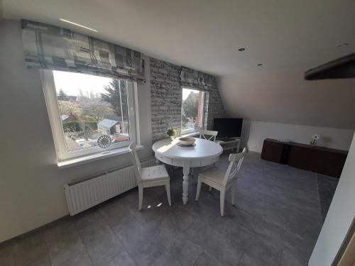 a dining room with a table and chairs and a window at Fischerbalje in Borkum
