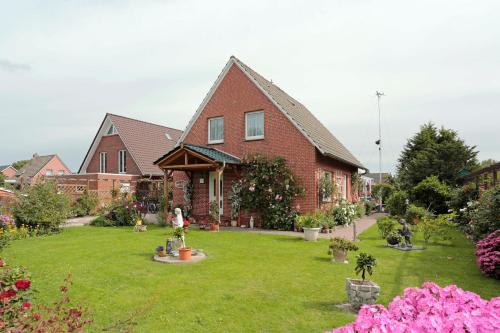a house with a yard with flowers in front of it at Fischerbalje in Borkum