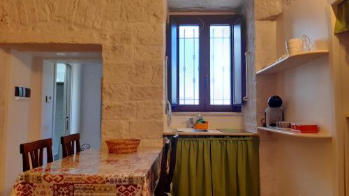 a kitchen with a table with a green table cloth at Pietra d'angolo in Locorotondo