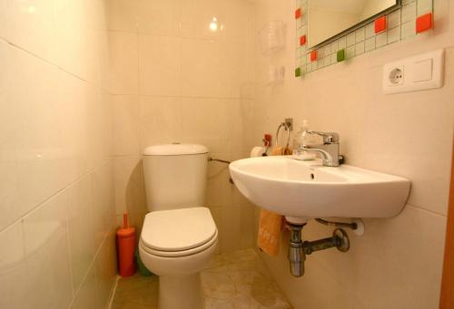 La salle de bains blanche est pourvue de toilettes et d'un lavabo. dans l'établissement Casa unifamiliar con patio y piscina en L'Estartit- Costa Brava, à L'Estartit