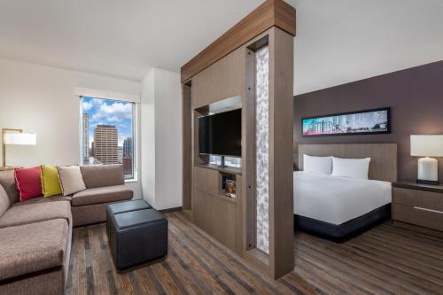 a hotel room with a bed and a couch at Hyatt House Denver/Downtown in Denver