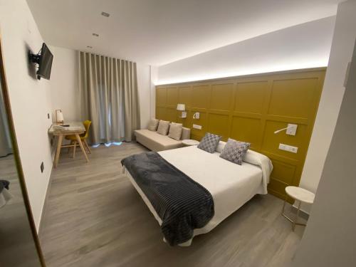 a hotel room with a large bed and a couch at Hotel Lusitania, Centro Ciudad, Parking Privado in Merida