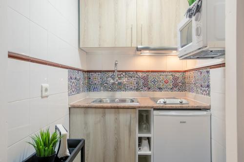 a small kitchen with a sink and a microwave at Apartment 233 Hispalis Triana in Seville