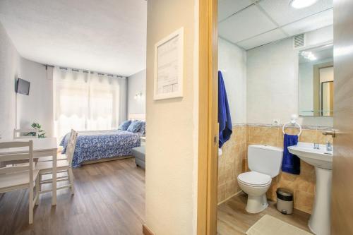a bathroom with a toilet and a bedroom with a bed at Apartment 233 Hispalis Triana in Seville